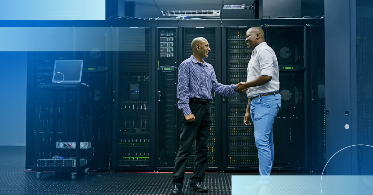 An image of two engineers shaking hands in a data center