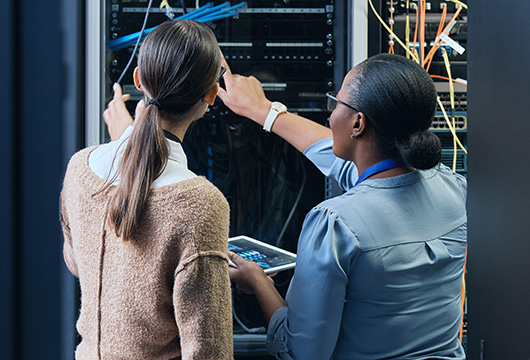 An image of two female engineers inspecting a server rack