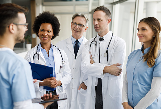 An image of a group of doctors and medical professionals congregated together conversing