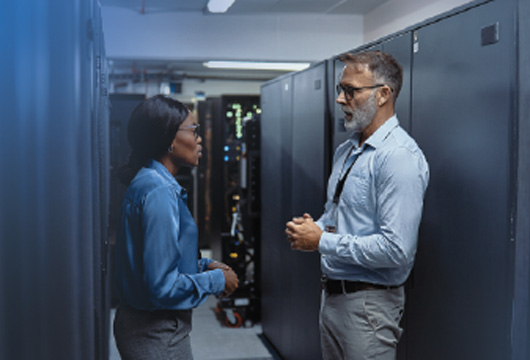 An image of two engineers having a conversation in a data center