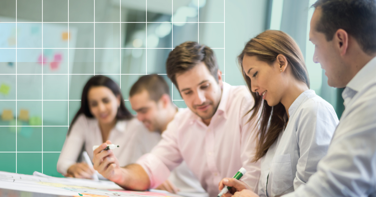 An image of collaborating professionals reviewing a paper with markers in hand