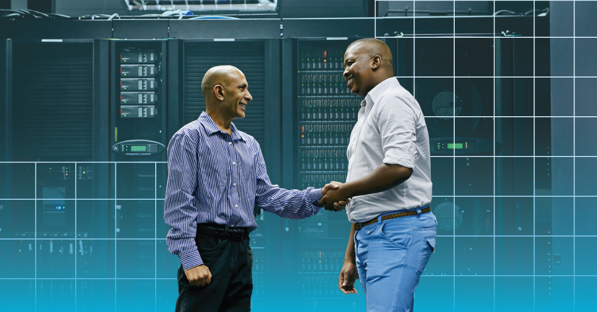 An image of two engineers shaking hands in a data center