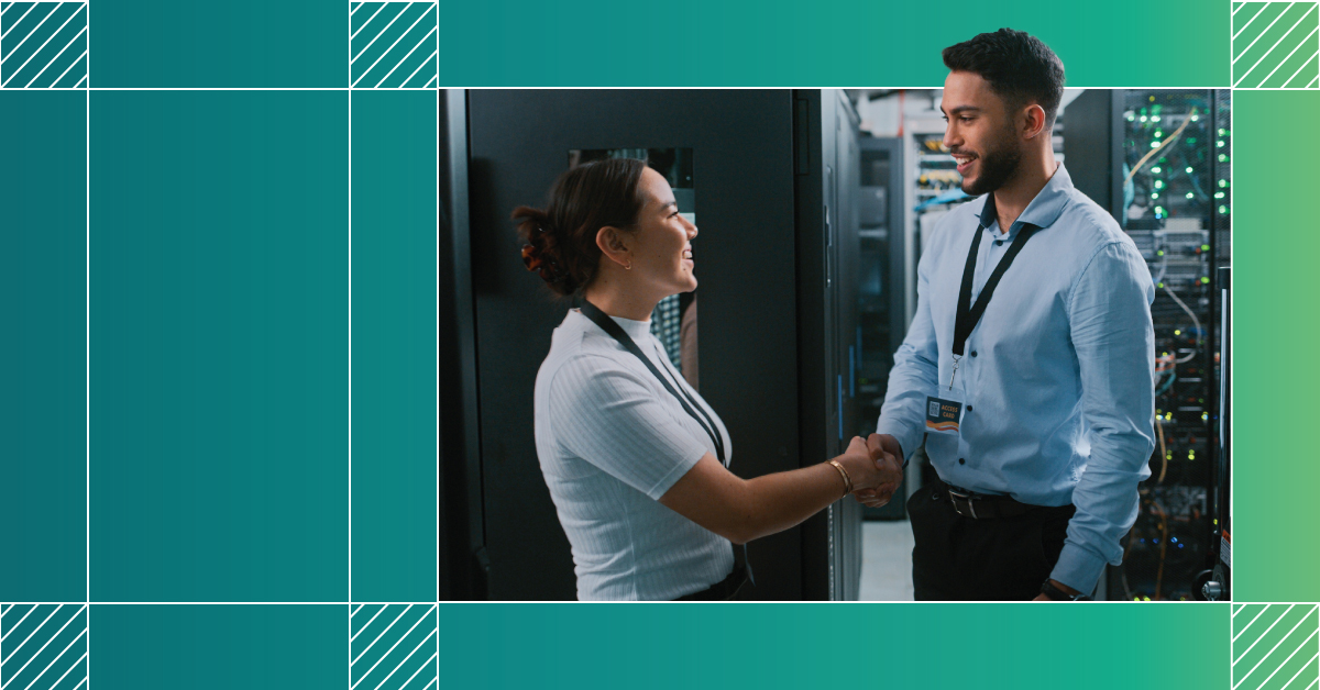 Female and male shaking hands while smiling in a data center