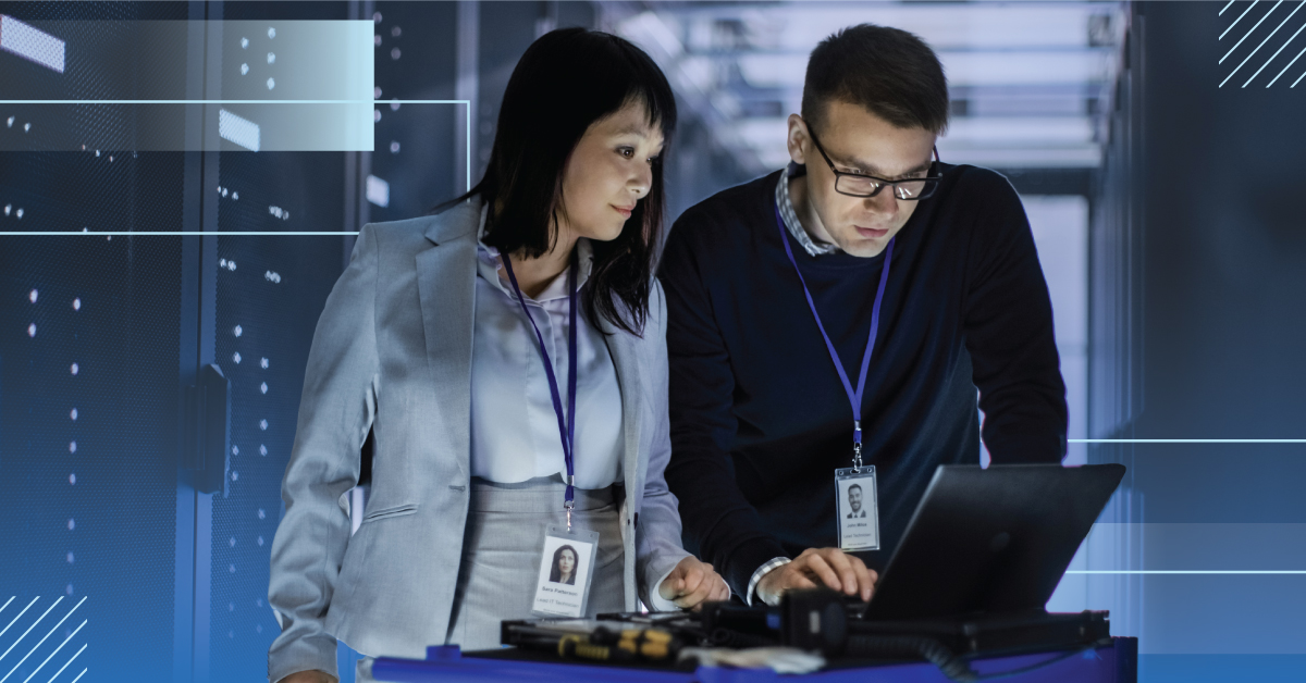 Female & male viewing laptop in data center