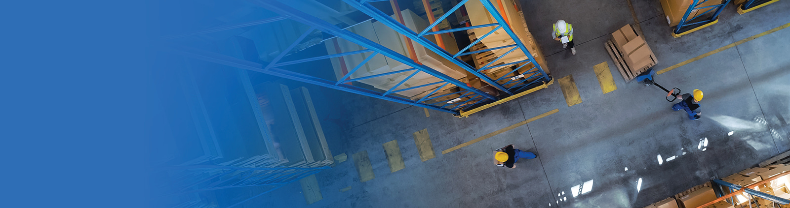 An overhead shot of a warehouse floor with workers in hardhats doing their tasks