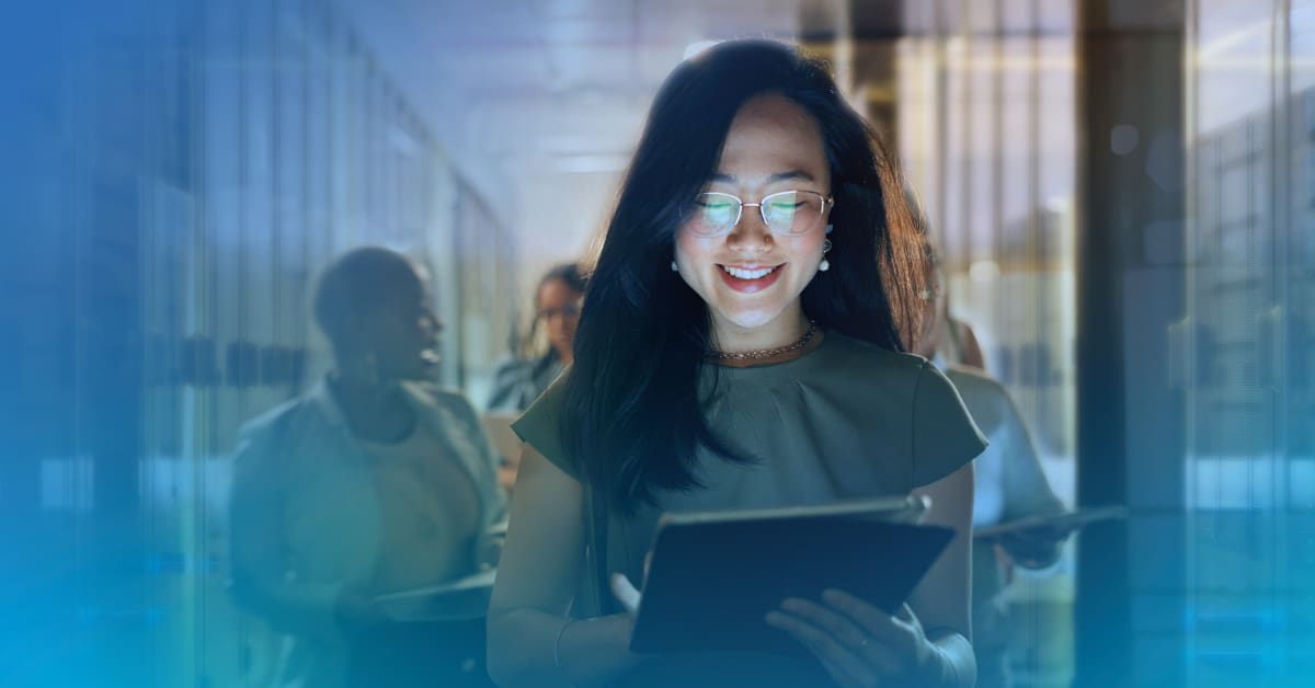 An image of a smiling woman using a tablet