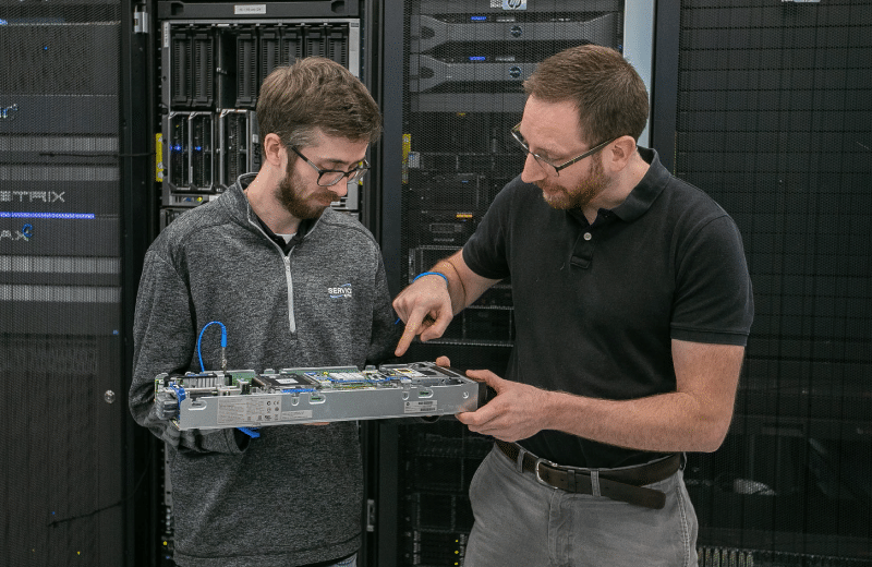 Engineers Studying a Motherboard in a Data Center
