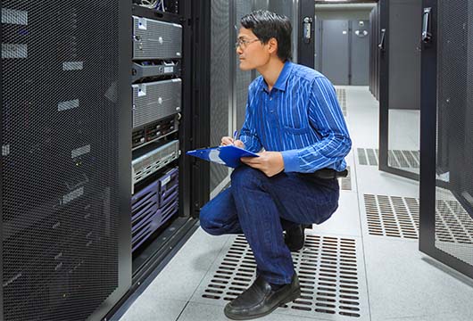 Engineer Kneeling in Server Room