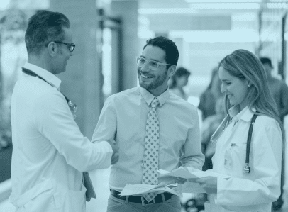 Three Hospital Professionals Discuss and Shake Hands