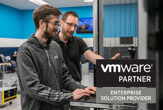 Two Engineers Discussing in Lab; VMware Partner Logo