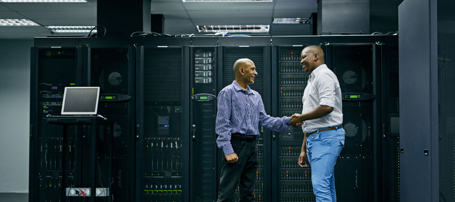 An image of two engineers shaking hands in a data center