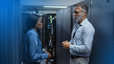 An image of a male and female engineer having a conversation in a data center
