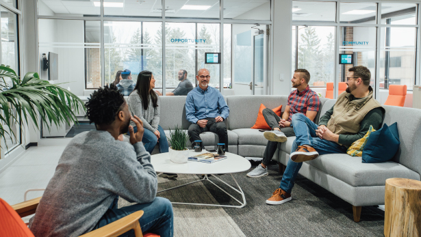 An image of a group of Service Express employees sitting on couches in a common area, having a conversation